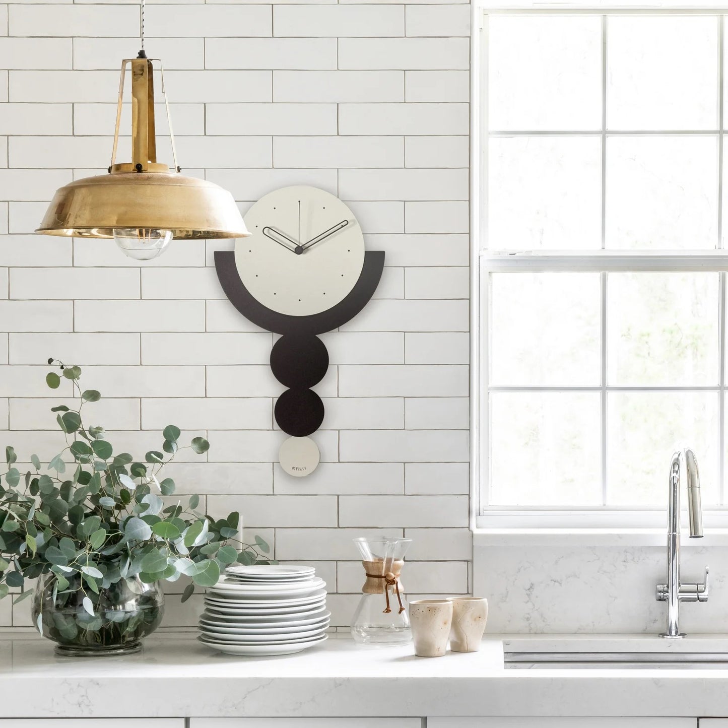 Questo orologio da parete in metallo bicolore con pendolo è caratterizzato da un design unico che si ispira alla "trilogia" dei cerchi. Dimensioni: cm 29 x 49,5 h. In negozio e online su tuttochic.it