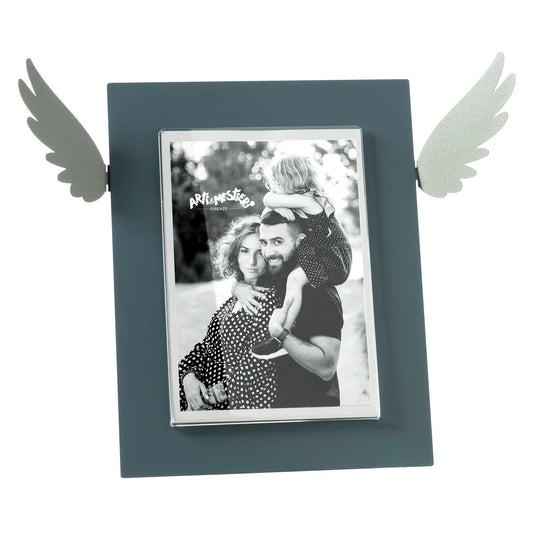 Portafoto Icaro di Arti e Mestieri. Realizzato in metallo colorato con le ali che si estendono dai lati, ispirato al mito di Icaro. Dimensioni: 33,3 x 25 h cm (13x18 formato foto). In negozio e online su tuttochic.it