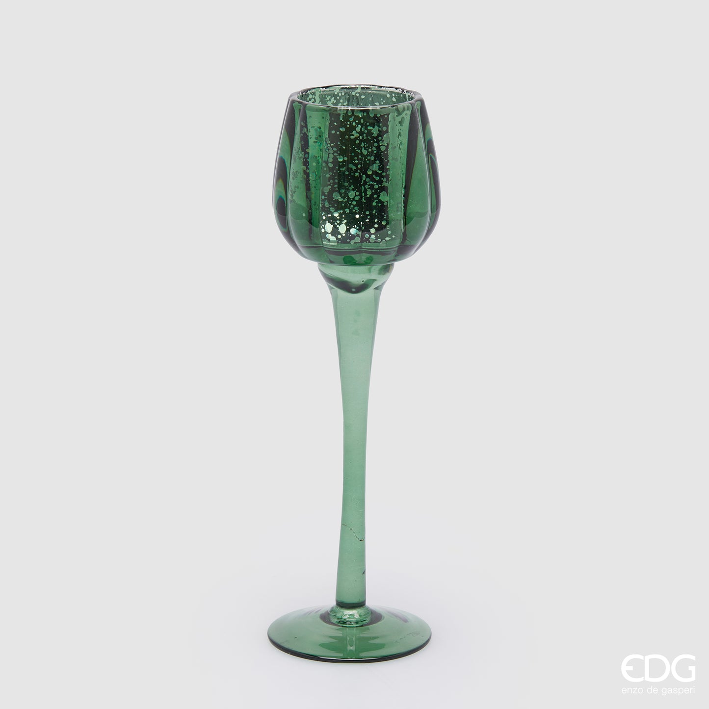 Calice portacandela in vetro lavorato di colore verde. Dimensioni: cm h 27,5 x ø 8. Per creare un'atmosfera raffinata ed elegante, si consiglia l'acquisto di più pezzi, di colori e misure diverse. In negozio e online su tuttochic.it