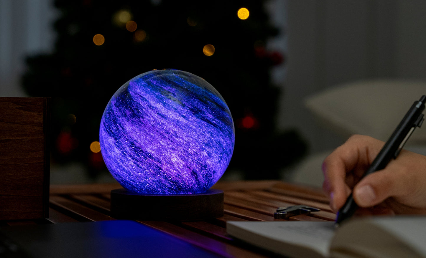 lampada AstraGlass Light. Composta da una sfera in vetro soffiata e dipinta a mano poggiata su una base rotonda in legno di noce americano. Questa lampada è perfetta per chiunque sia affascinato dal meraviglioso fenomeno naturale del nostro mondo. Dimensioni: cm ø 12 x h 13. In negozio e online su tuttochic.it