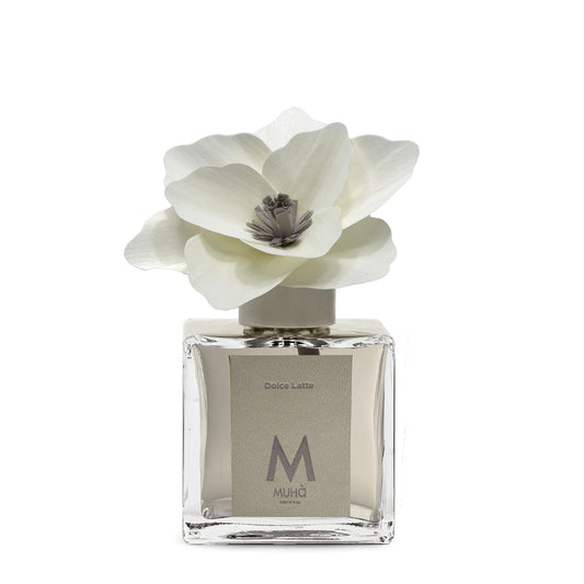 Diffusore d’ambiente con bottiglia in vetro con tappo in zama si accompagna a una magnolia in legno di betulla per diffondere 250 ml di fragranza Dolce Latte. tuttochic.it