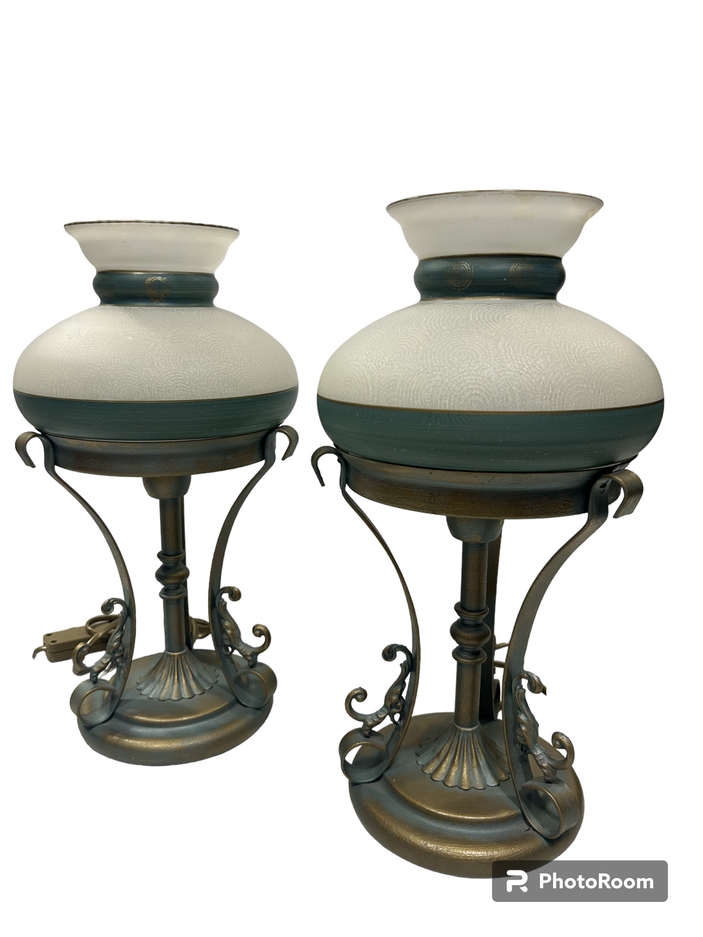 Set di 2 lampade in stile classico in metallo di colore oro e verde (effetto verderame), coppe in vetro sabbiato decorate a mano. Corredate di cavo con interruttore, funzionano con una lampadina attacco piccolo E14 (non incluse). Dimensioni: cm 18 x 35 h - base cm 14. In negozio e online su tuttochic.it