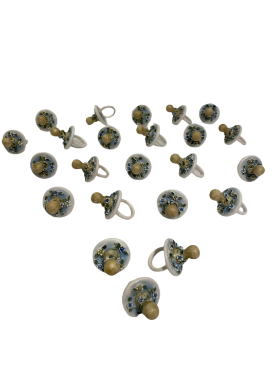 Set di 23 ciucciotti in porcellana stile capodimonte con sfumature di colore celeste. Dimensioni: cm 4,5 x 7 Confettata e astuccio non inclusi. tuttochic.it