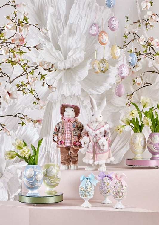 Aggiungi un tocco di eleganza pasquale alla tua casa con il Coniglio Dandy. Realizzato in resina bianca di alta qualità, questo grazioso decoro è abbellito da un vestito in vero tessuto decorato, per un'atmosfera di raffinatezza. Dimensioni: altezza cm 51. In negozio e online su tuttochic.it