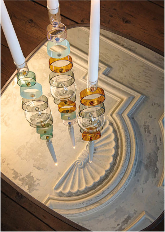 Crea un'atmosfera di classe e raffinatezza nella tua casa con il portacandela della collezione "Cerchiando" di Rituali Domestici. Realizzato in vetro borosilicato, questo portacandela aggiunge un tocco di eleganza e resistenza al tuo spazio. Dimensioni: Ø 8 x 34.5 h cm. In negozio e online su tuttochic.it