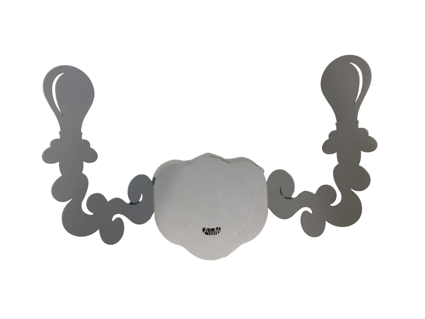 Appendiabiti da parete in metallo che raffigura un applique con due ganci laterali a forma di lumetti. Dimensione: 35 x 24 H (massimo ingombro)Materiale: ferro verniciato a polvere epossidica di colore grigio alluminio. In negozio e online su tuttochic.it