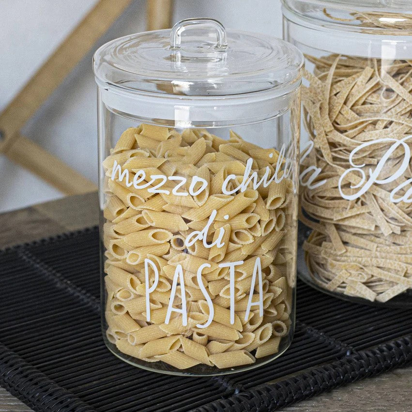 Il barattolo di vetro borosilicato trasparente, con la scritta "mezzo chilo di pasta" e la guarnizione ermetica, è ideale per conservare i tuoi alimenti preferiti in modo sicuro e stiloso. Dimensioni: ø 12 x h 20 cm. In negozio e online su tuttochic.it