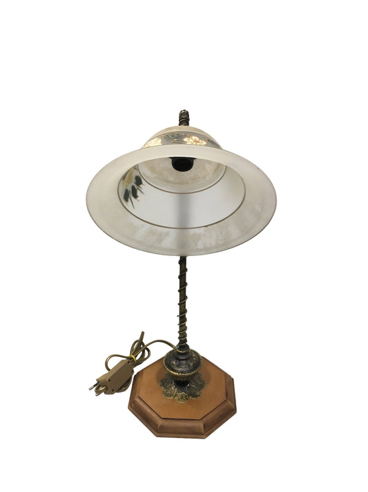 Lampada da tavolo in stile classico con braccetto in metallo di colore bronzo e oro, base in legno di forma ottagonale e coppa in vetro sabbiato decorato a mano, funziona con una lampadina attacco piccolo E14 (non inclusa). Dimensioni: cm 25 x 40,5 h - base cm 16 x 16. In negozio e online su tuttochic.it