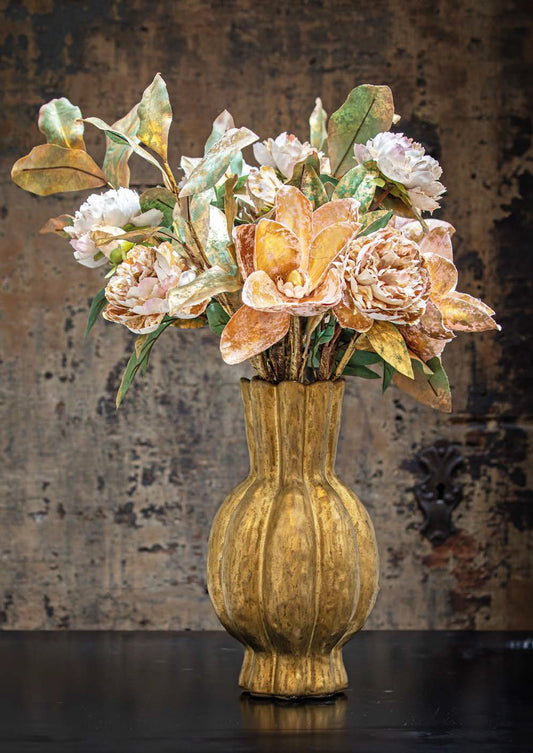 Il vaso portafiori della collezione "CRISO" di Rituali Domestici è un pezzo unico, realizzato in pregiata ceramica color oro opaco. L'opulenza della sua tonalità e la maestria artigianale conferiscono un tocco di lusso a qualsiasi ambiente. Dimensioni: Ø 19.5 x 35 h cm. In negozio e online su tuttochic.it