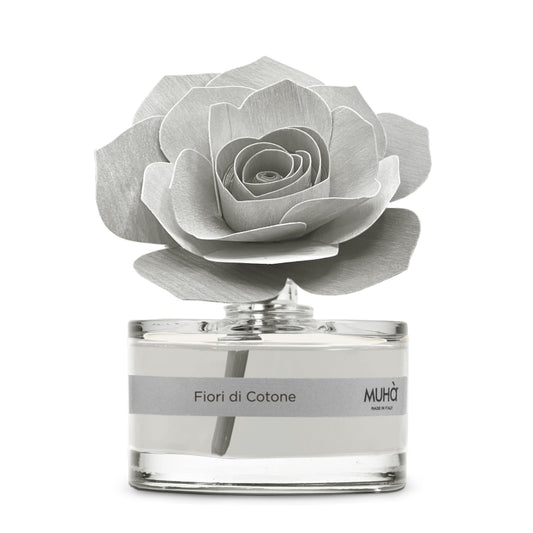 Una raffinata confezione in bottiglia di vetro, con diffusore a forma di rosa in legno di betulla naturale realizzato a mano. Completo di essenza 50 ml. FIORI DI COTONE  Fragranza delicata e soave con note di bergamotto si uniscono ad un cuore fiorito di mughetto, vaniglia. In negozio e online su tuttochic.it