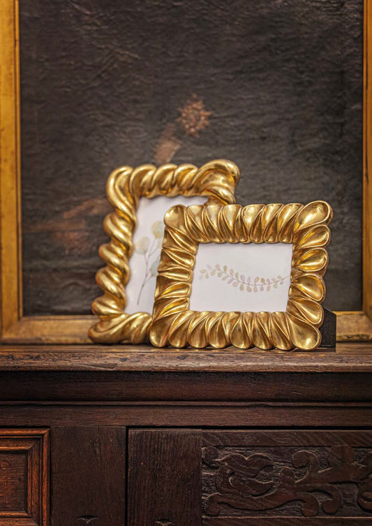 Elegante portafoto della collezione "Guardandoti" di Rituali Domestici, realizzato in pregiata resina color oro, conferisce un tocco di lusso e stile ad ogni ambiente. Oltre a essere poggiato, lo stesso può essere appeso. Dimensioni: cm 20 x h 24,5 - dimensione foto cm 13 x 18. In negozio e online su tuttochic.it