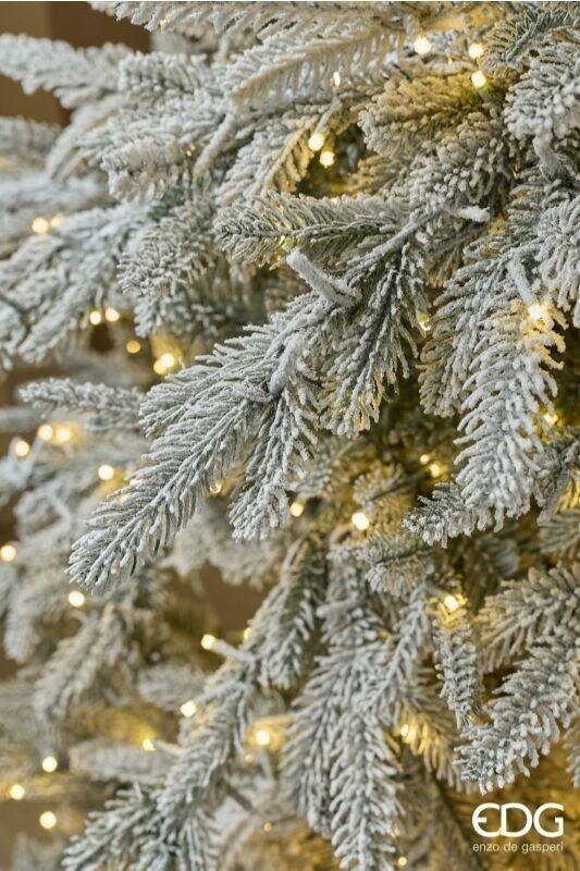 Dettaglio ravvicinato dei rametti innevati Real Touch in PE del Pino Cortina di EDG Enzo De Gasperi con micro luci Mini LED brillanti tra la neve.