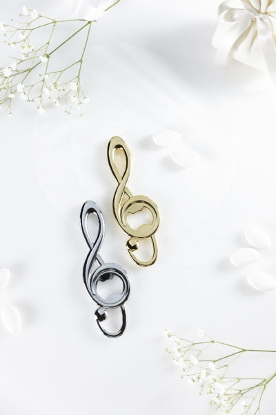 L’apribottiglia Sound, dalla forma a chiave di violino dallo stile raffinato ed elegante. Rappresenta un'idea regalo preziosa per celebrare un momento speciale anche come bomboniera. Realizzato in zama, di colore oro 24k. Dimensioni: 14,5 x 5 x 0,8 cm. Si consiglia di lavare a mano. In negozio e online su tutttochic.it