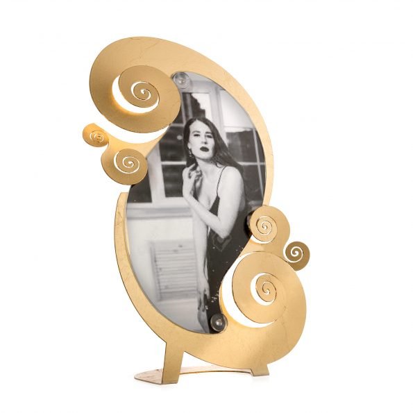 Porta foto elegante e moderno da tavolo in metallo lavorato e colorato con foglia oro, perfetto per incorniciare i momenti più importanti. Dimensione: 19×30 (foto14 x 23 h) L’articolo è fornito di plexiglass trasparente sagomato. In negozio e online su tuttochic.it