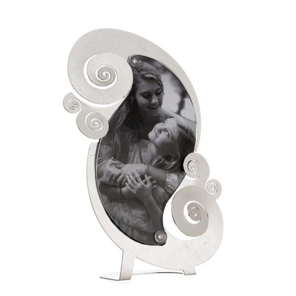 Porta foto elegante e moderno da tavolo in metallo lavorato e colorato con foglia d'argento, perfetto per incorniciare i momenti più importanti. Dimensione: 19×30 (foto14 x 23 h) L’articolo è fornito di plexiglass trasparente sagomato. In negozio e online su tuttochic.it