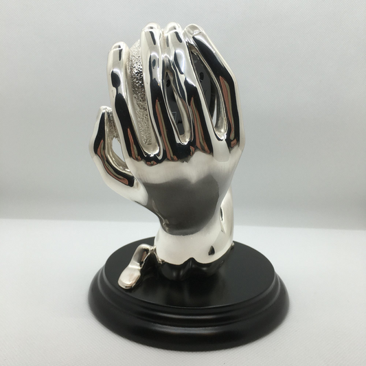 Scultura corpo-mano con orologio e sveglia in bagno galvanico in argento. Dimensioni: cm 15 x 17 h. In negozio e online su tuttochic.it