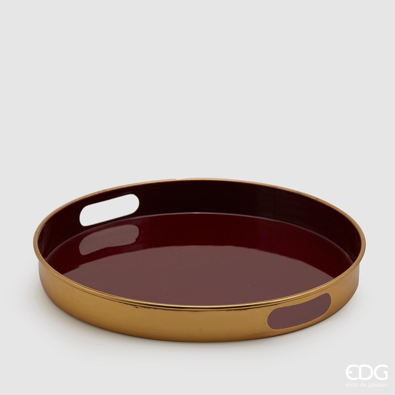 Vassoio tondo in metallo color oro con piano d'appoggio smaltato di colore bordò. Dimensioni: diametro cm 37, altezza cm 5,5. In negozio e online su tuttochic.it