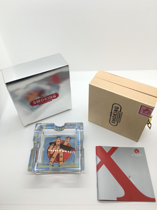 Posacenere quadrato in cristallo con decoro progettato da Kunstflug nel 2002, Edizione Limitata, della linea "Smoking Xclusive" di Ritzenhoff. Custodito in una scatola di legno con cerniere e chiusura in metallo Dimensioni: mm. 100 x 100