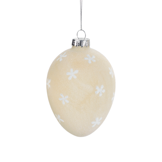 Uovo da appendere in vetro satinato di colore beige decorato con fiorellini bianchi. Dimensioni: Ø 7 x 10,5. In negozio e online su tuttochic.it
