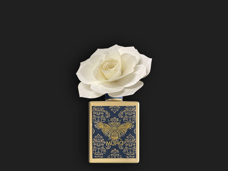 Profumatore per ambiente in una raffinata bottiglia di vetro verniciato con etichetta tessuta in jacquard e diffusore a forma di fiore in legno di betulla da 200 ml. FIORI DI COTONE Fragranza delicata e soave con note di bergamotto unite ad un cuore fiorito di mughetto, vaniglia ecc. In negozio e online su tuttochic.it