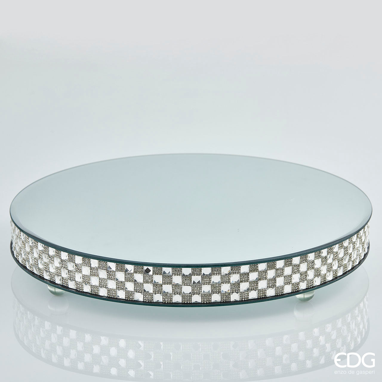 Alzata a specchio con bordo decorato di strass e gemme in acrilico. Ideale per servire dolcetti o come base per evidenziare oggetti. Diametro: cm 41, altezza cm 7. In negozio e online su tuttochic.it