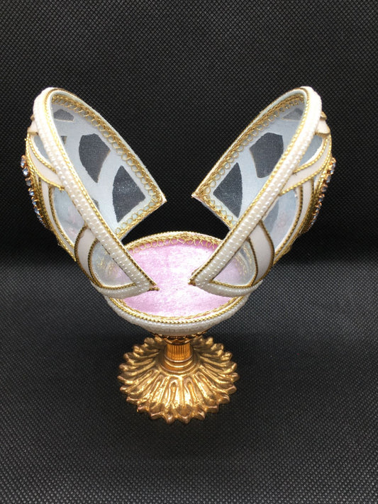 Vero uovo d'oca lavorato e decorato di colore bianco con applicazioni di strass, perline e cordoncino dorato, apribile porta gioie. Dimensioni: diametro interno cm 6,5 x 12,5 h esterno