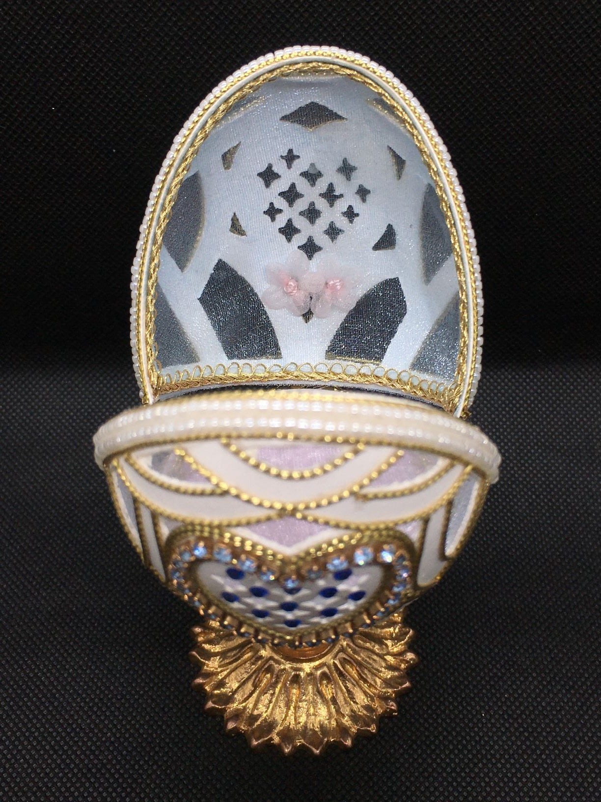 Vero uovo d'oca lavorato e decorato di colore bianco con applicazioni di strass, perline e cordoncino dorato, apribile porta gioie. Dimensioni: diametro interno cm 6,5 x 12,5 h esterno