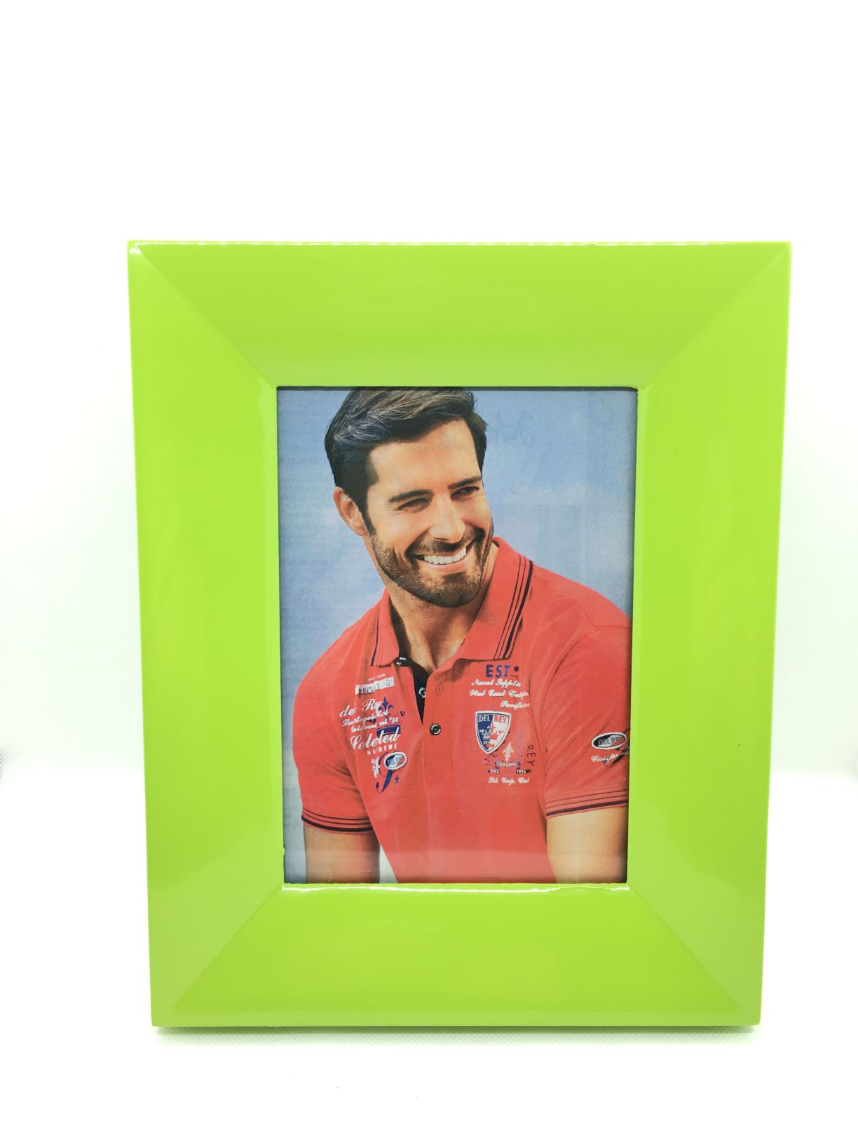 Portafoto in legno laccato di colore verde mela. Possibilità di poggiarlo o appenderlo sia in orizzontale che verticale. Dimensioni: cm 20 x 10 x 25 h (dimensione foto 13 x 18)