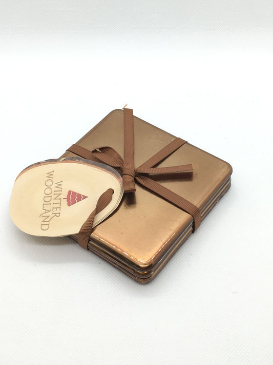 Set di 4 sottobicchieri in plastica effetto metallo di colore oro/bronzo. Dimensioni: sottobicchiere singolo cm 10 x 10. In negozio e online su tuttochic.it