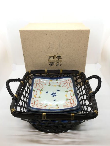 Set di 6 piattini in porcellana giapponese Saiegawari con cestino in vimini di colore nero. Dimensioni: piattino cm 14 x 14 - cestino cm 19, 5 x 25 (con manici) x 11,5 h (con manici). In negozio e online su tuttochic.it