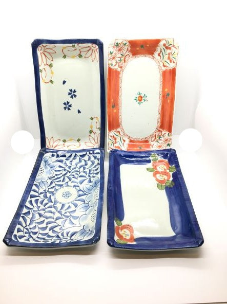 Set di 4 vassoietti rettangolari in porcellana giapponese Saiegavari con decori diversi. Dimensioni singolo piattino: cm 24,5 x 14,5 x 2,5 h. In negozio e online su tuttochic.it
