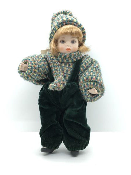 Bambola in porcellana di Capodimonte fatta e dipinta a mano, con mirabile fusione di tecnica e abilità manuale. Corpo, braccia e testa in porcellana snodabile, vestito con velluto verde scuro e cotone multicolorato. Dimensioni: cm 13 x 22 h. In negozio e online su tuttochic.it