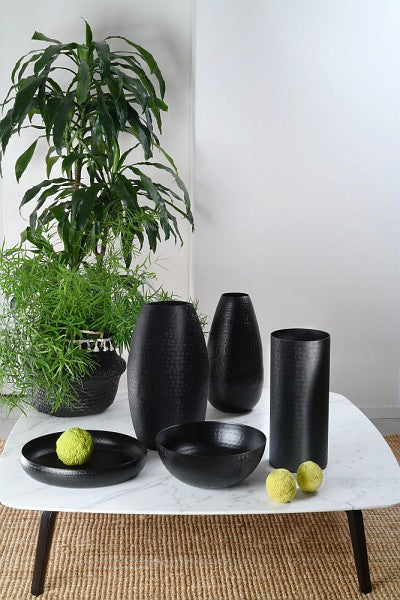 Vaso cilindrico in alluminio di colore nero. Dimensioni: cm 17 x 39H La linea atelier è realizzata in alluminio cesellato, leggero nelle forme e nel peso. In negozio e online su tuttochic.it