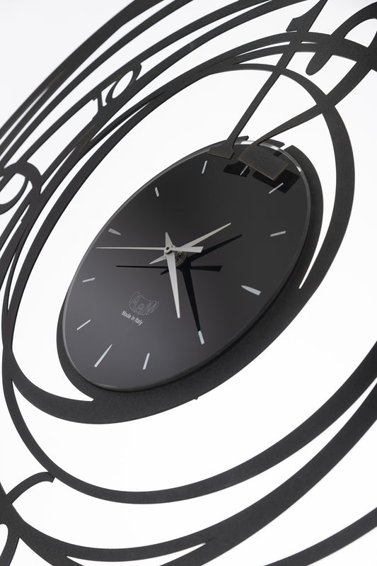 Orologio da parete in metallo di colore nero. Ghirigoro è un orologio da parete la cui particolarità sono le linee circolari che si sviluppano dal quadrante interno fino a formare una cornice tutto intorno. Il quadrante centrale è piccolo e minimal. Diametro 70 cm. In negozio e online su tuttochic.it