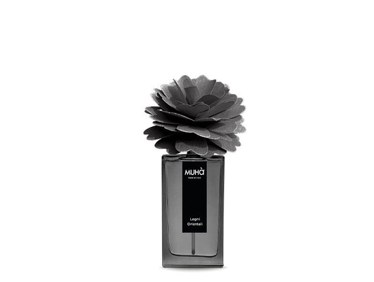 Profumatore per ambiente in una raffinata bottiglia in vetro colorato con etichetta effetto soft-touch con scritte dorate e diffusore a forma di fiore in legno di betulla naturale realizzato a mano. Completo di essenza da 50 ml. fragranza LEGNI ORIENTALI Fresche note... In negozio e online su tuttochic.it