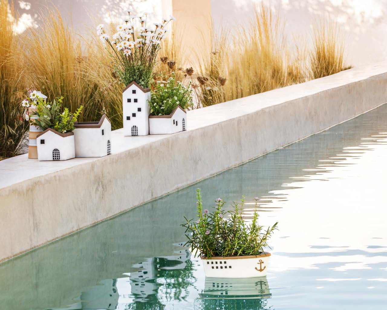 Cachepot a forma di casetta in resina cementizia decorata. Dimensioni: cm 10.5 x 10.5 x 24 h. In negozio e online su tuttochic.it