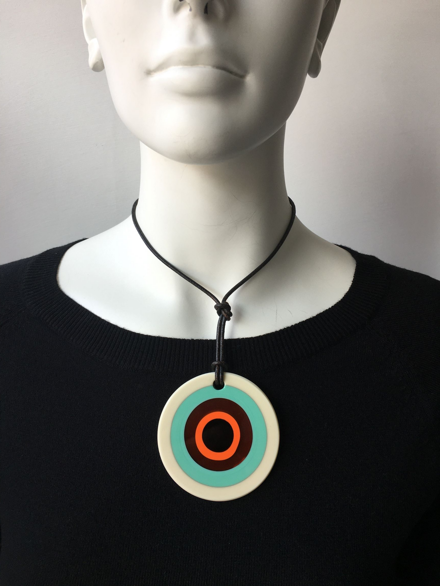 Pendente in cristallo di Murano rifinito a mano con motivi decorativi applicati a caldo: murrina ad anelli. Dotato di laccetto in cuoio. Dimensioni: diametro cm 6,5