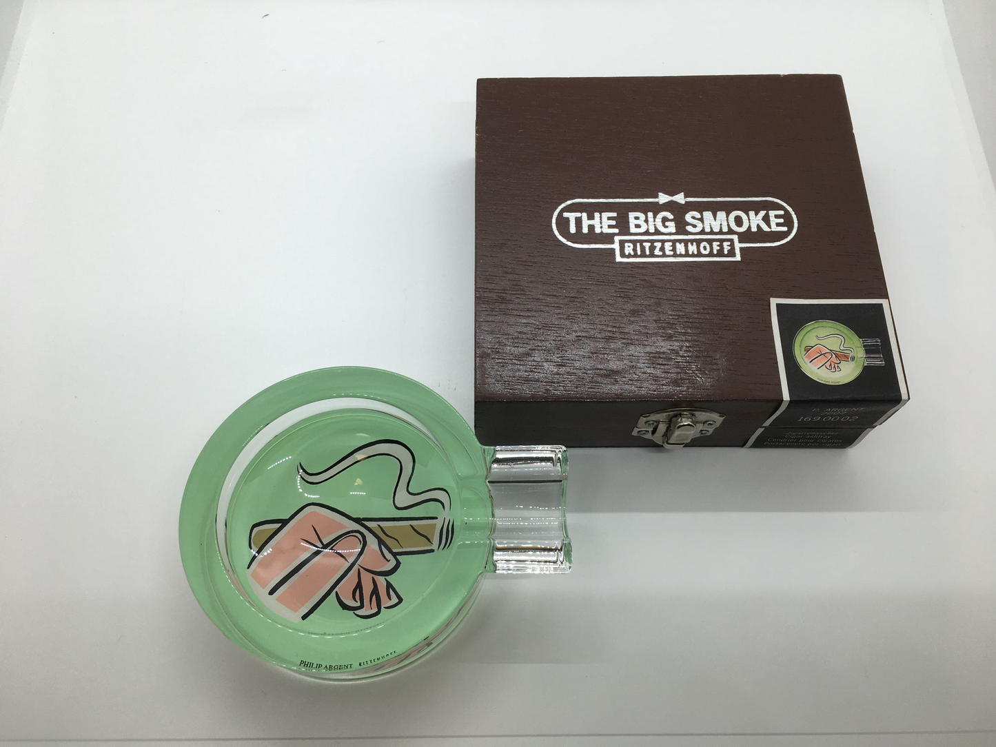 Posacenere in cristallo con decoro progettato da P. Argent nel 2002, Edizione Limitata, della linea "The Big Smoke" di Ritzenhoff. Custodito in una scatola di legno con cerniere e chiusura in metallo Dimensioni: diametro 95 mm. altezza 35 mm. In negozio e online su tuttochic.it