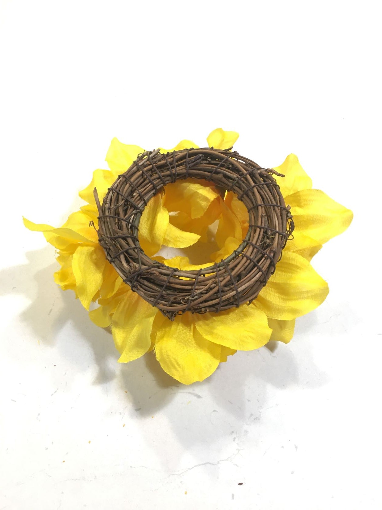Corona girocandela decorata con fiorellini di Daffodils (Narcisi) artificiali, diametro cm 15. Ideale per candele a forma di moccolo o sfera da 5 cm di diametro. In negozio e online su tuttochic.it