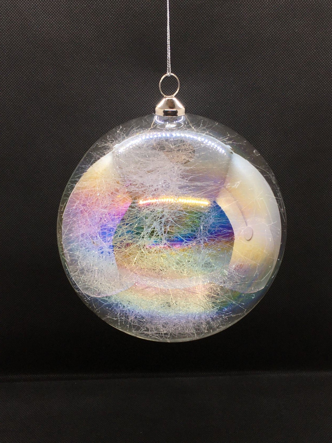 Sfera in vetro trasparente effetto Iride e decorata all'interno con fili di vetro. Decorazione per albero di Natale. Dimensione: diametro cm 15. In negozio e online su tuttochic.it