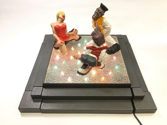 Pista da ballo illuminata (senza statuine) della linea "Ballerini in Discoteca" di Antartidee. Composta da una pista in metallo con luci colorate e coperte da un vetro, 4 gradini laterali in resina di colore antracite, 4 angolari in metallo di colore antracite. Dimensioni totali: cm 43,5 x 43,5 x 7 h