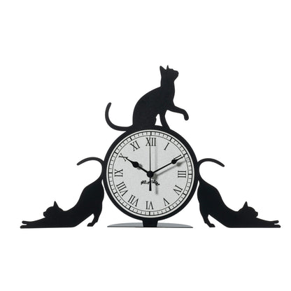 Orologio simpatico Cattitude da tavolo, realizzato in ferro e di colore nero, il complemento d’arredo originale e simpatico da collocare in una scrivania dello studio oppure sul comodino di una camera rappresenta l’allegria e la freschezza degli ambienti. Dimensioni: 48 X 30H cm. In negozio e online su tuttochic.it