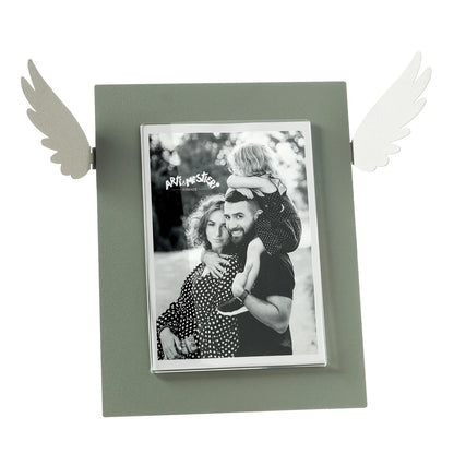 Portafoto Icaro di Arti e Mestieri. Realizzato in metallo colorato con le ali che si estendono dai lati, ispirato al mito di Icaro. Dimensioni: 33,3 x 25 h cm (13x18 formato foto). In negozio e online su tuttochic.it