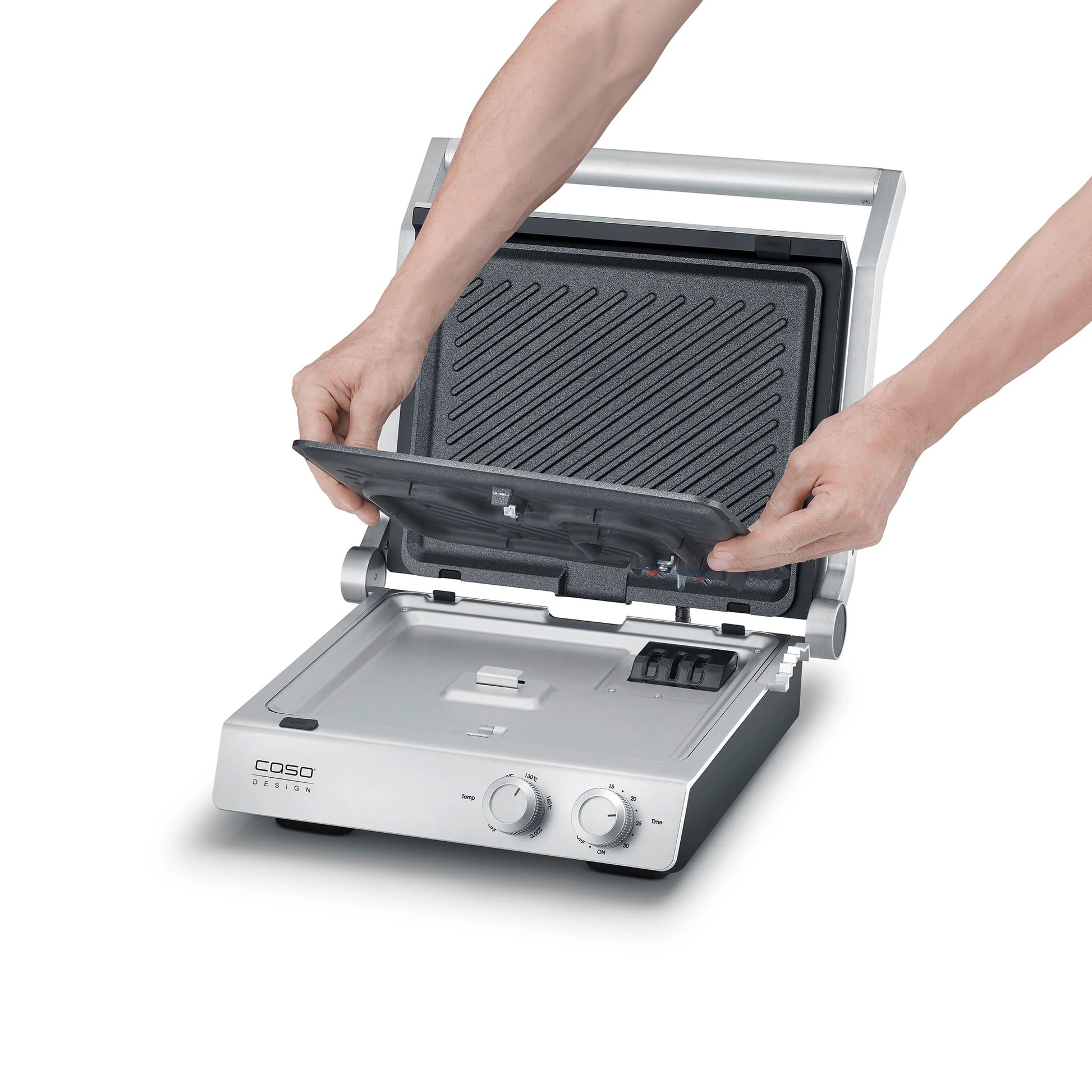 Piastra elettrica SteakChef CASO Design aperta su tavolo da cucina con bistecche in cottura