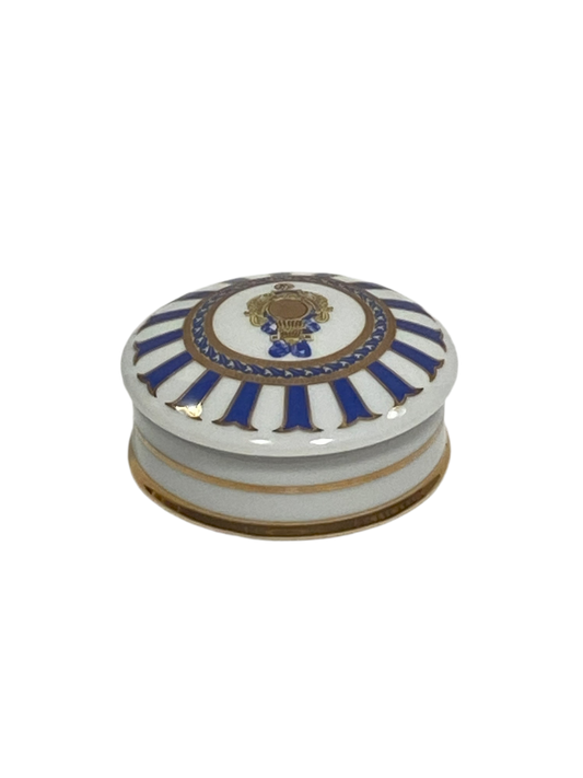 Scatolina tonda con coperchio bombato in porcellana Limoges con decoro in oro zecchino e blu. Dimensioni: cm ø 7,5 x h 3,5. In negozio e online su tuttochic.it