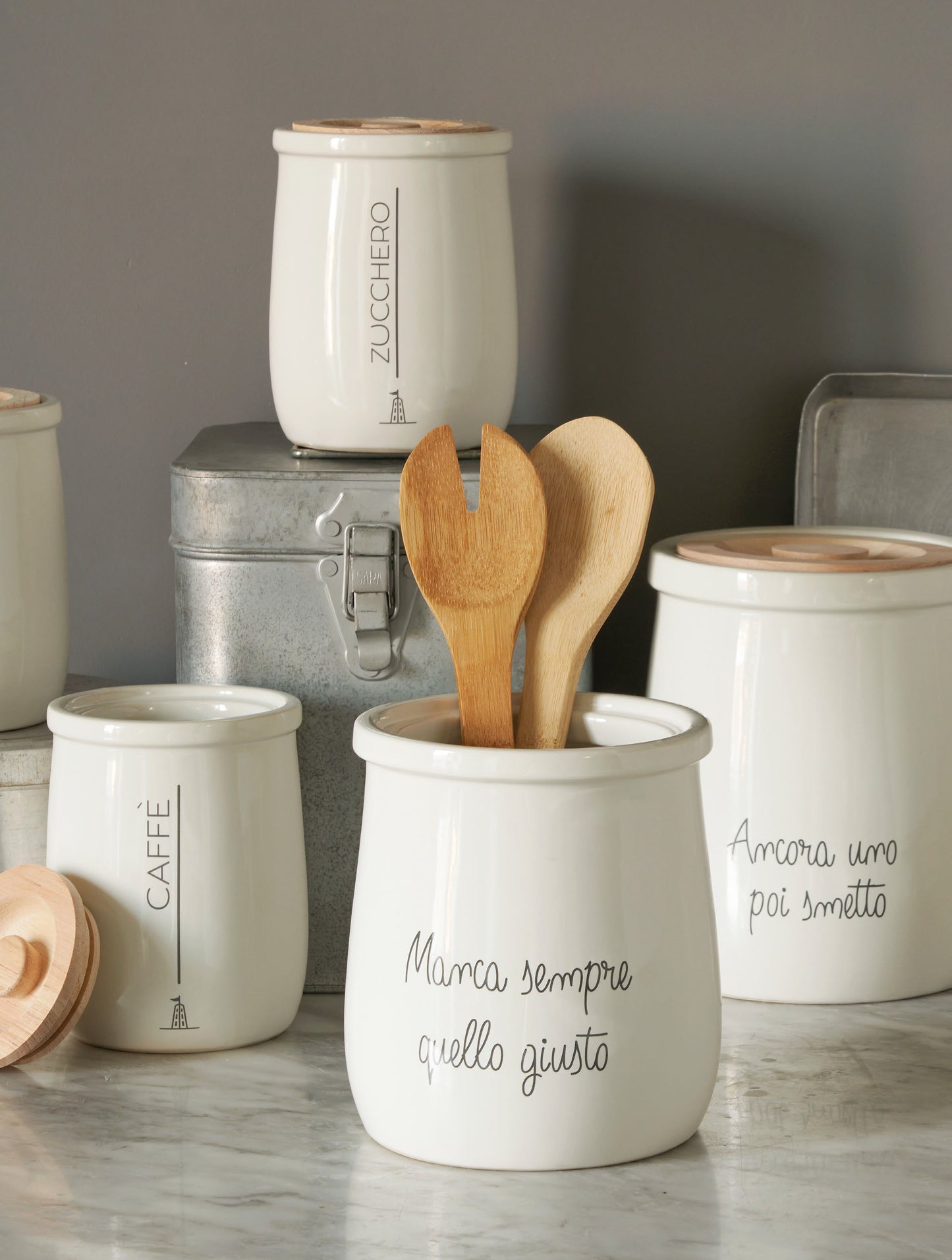 Biscottiera tonda in porcellana bianca decorata con coperchio ermetico in legno chiaro. Dimensioni: cm Ø 16 x h 19 - capacità 2,5 litri. In negozio e online su tuttochic.it