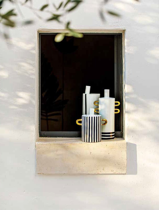 Composizione di vasi in porcellana bianco, nero e oro della collezione Guardacheeblu di Rituali Domestici esposti su davanzale.