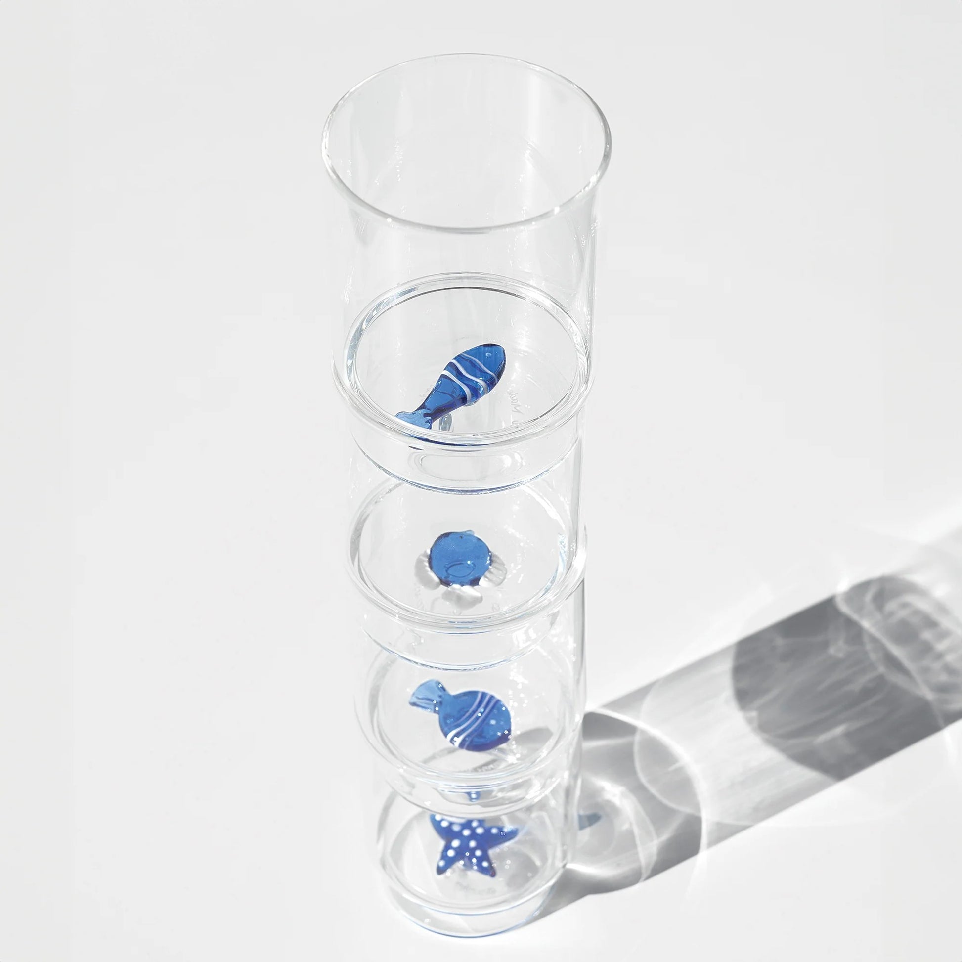 Il set Teca Mare è composto da 6 bicchieri contenenti sei diversi decori a tema “marino”, di colore bianco/blu: la stella di mare, il riccio di mare, il corallo, la sardina, il pesce palla e il pesce bicolore, tutti realizzati a mano. Dimensioni: Ø 8x h 10,5 cm - 35 cl. In negozio e online su tuttochic.it