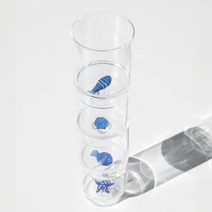 Il set Teca Mare è composto da 6 bicchieri contenenti sei diversi decori a tema “marino”, di colore bianco/blu: la stella di mare, il riccio di mare, il corallo, la sardina, il pesce palla e il pesce bicolore, tutti realizzati a mano. Dimensioni: Ø 8x h 10,5 cm - 35 cl. In negozio e online su tuttochic.it