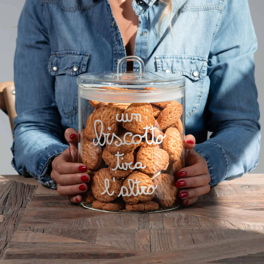 La Biscottiera "un biscotto tira l'altro" di Simple Day è elegante e funzionale, realizzata in pregiato vetro borosilicato trasparente con guarnizione ermetica per mantenere i biscotti freschi e croccanti. Dimensioni diametro 12 cm x altezza 20 cm  In negozio e online su tuttochic.it